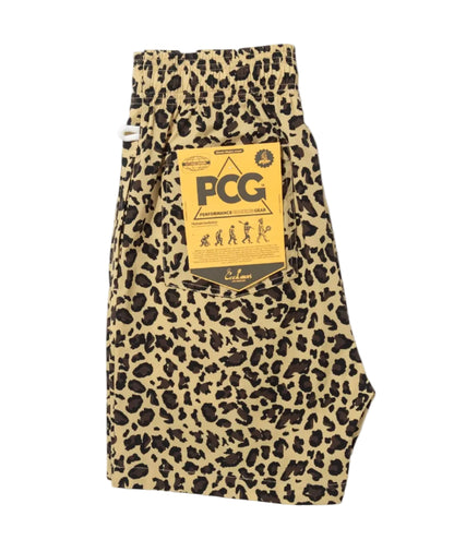 A pair of leopard print shorts in beige and black, featuring a prominent yellow hangtag with 'PCG' branding, displayed on a clean white background.