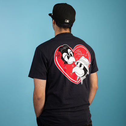 Person wearing a black t-shirt with a heart-shaped graphic on the back against a blue background