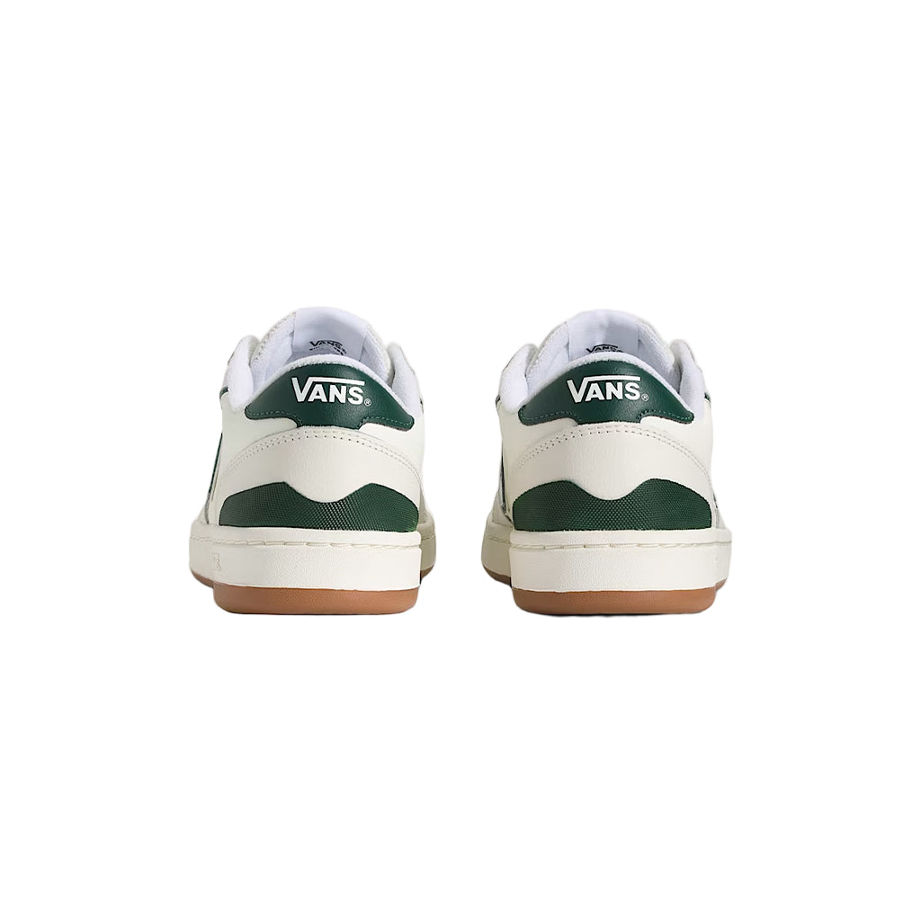 Pair of Vans sneakers with green and white design on a light background