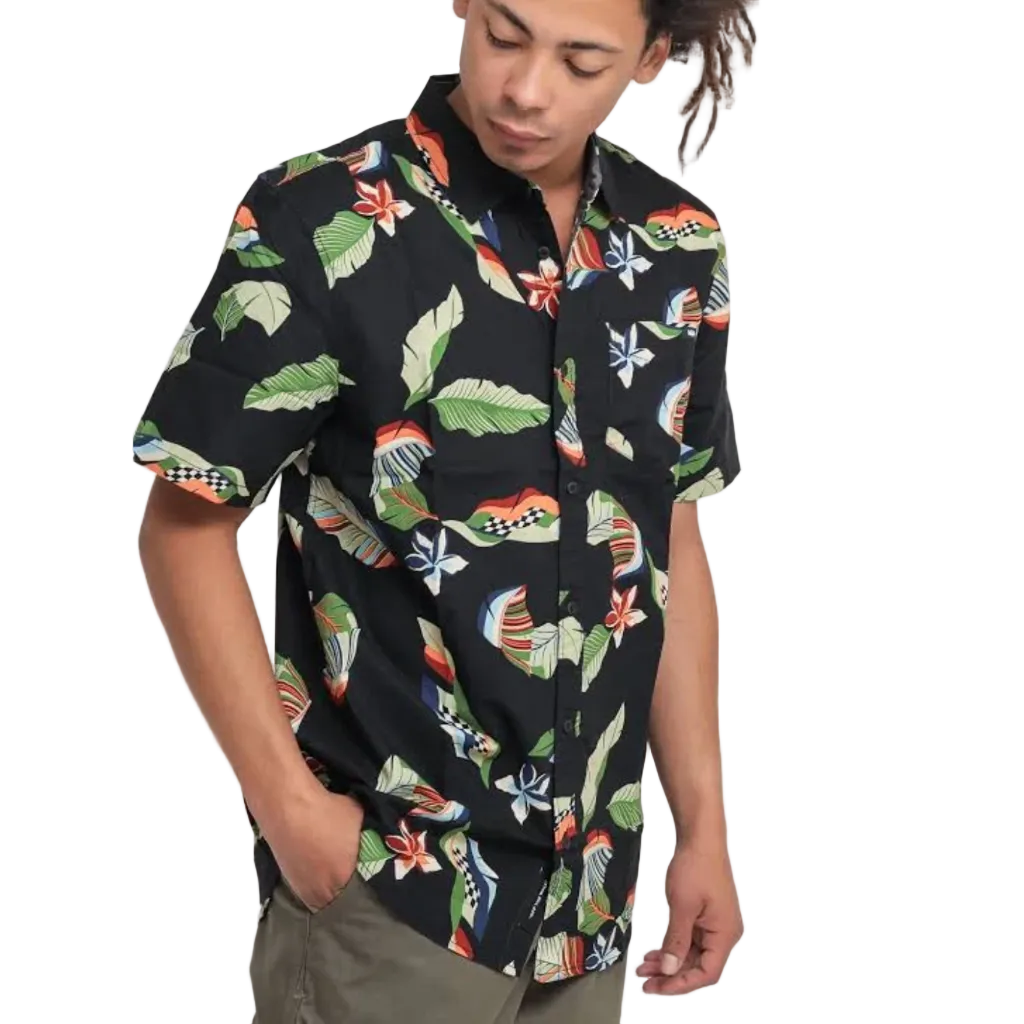 A man wearing a black short-sleeve button-up shirt with a colorful tropical leaf and bird pattern, paired with olive green pants, set against a plain white background.