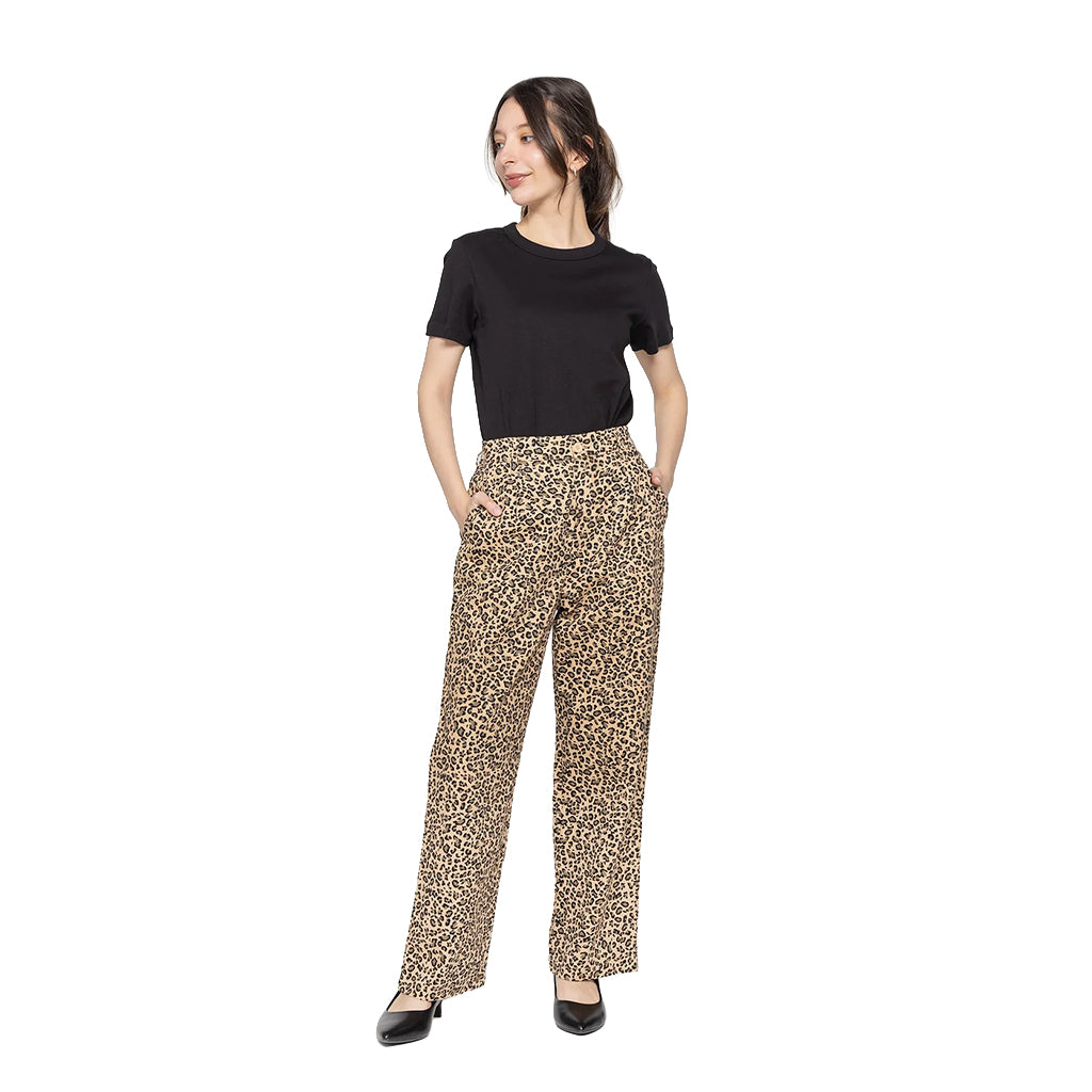 Woman wearing a black top and leopard print pants on a white background
