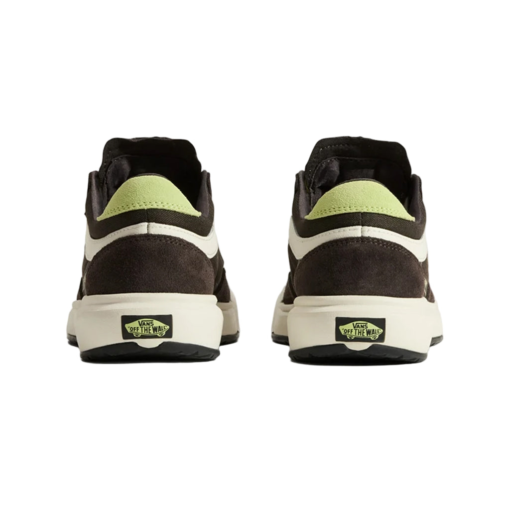 Pair of black and brown sneakers with green accents on a beige background