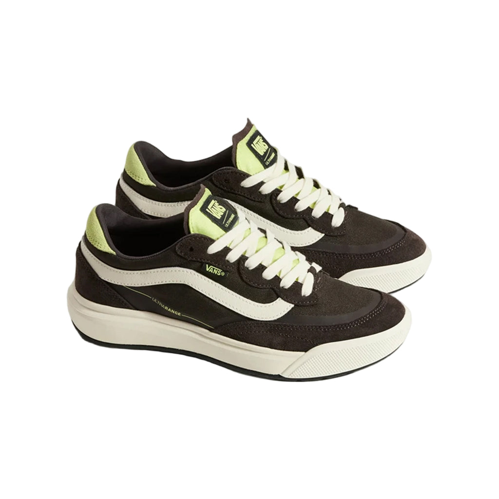 Black and white sneakers with green accents on a light beige background