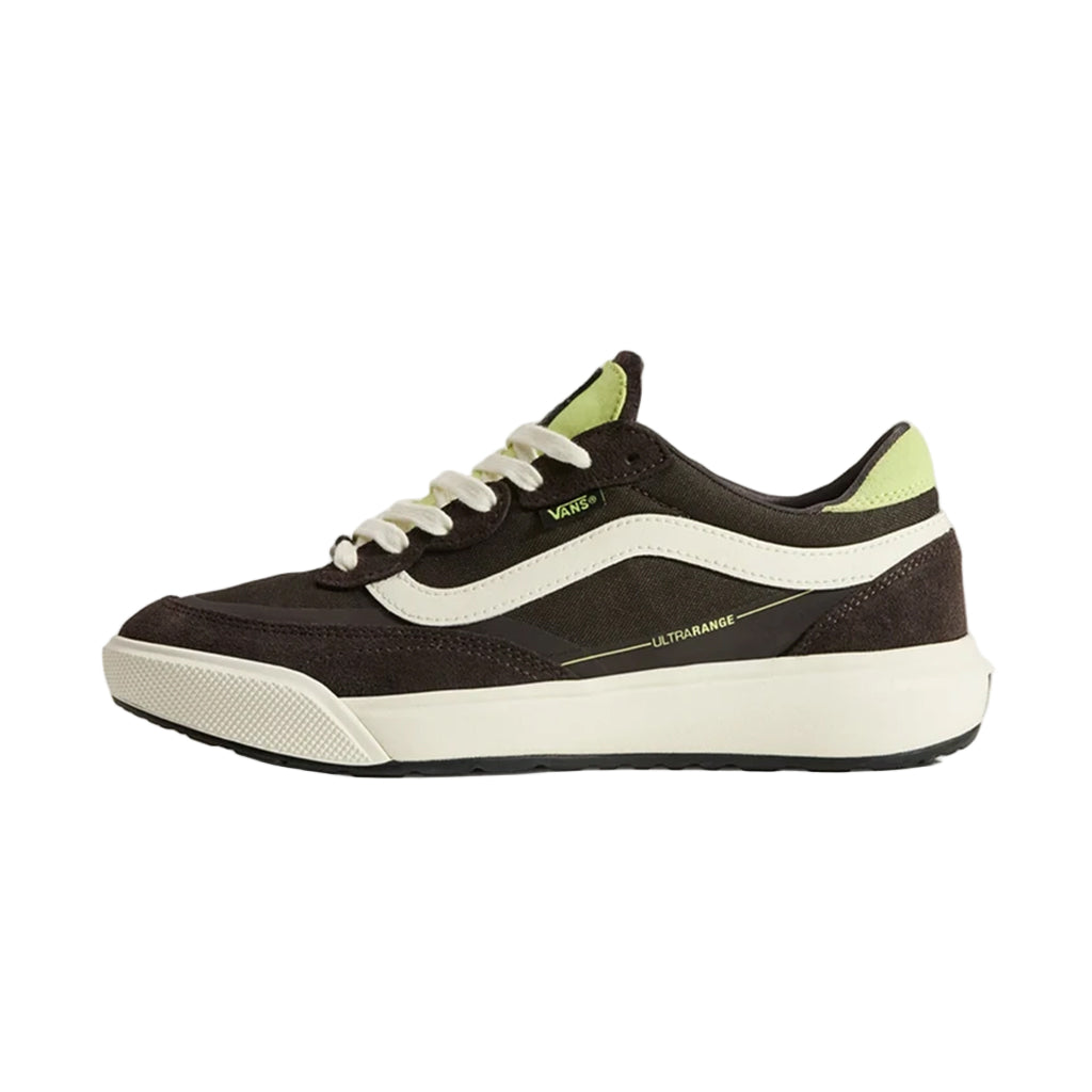 Black and white sneaker with green accents on a beige background
