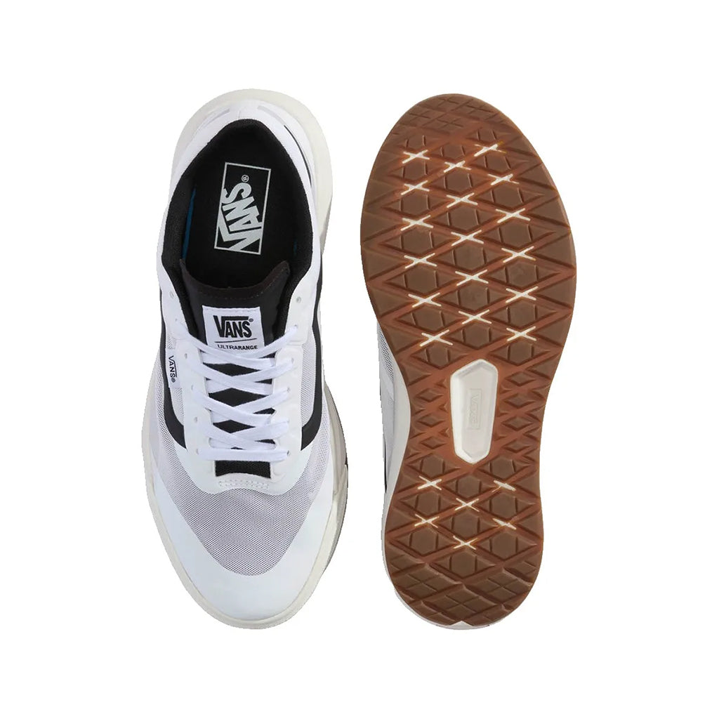 White sneaker with black accents and brown sole on a white background