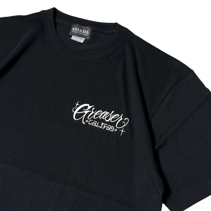 A black short-sleeve t-shirt with a white cursive 'Greaser' graphic and 'GALAXY+' text printed on the left chest, shown on a plain white background.