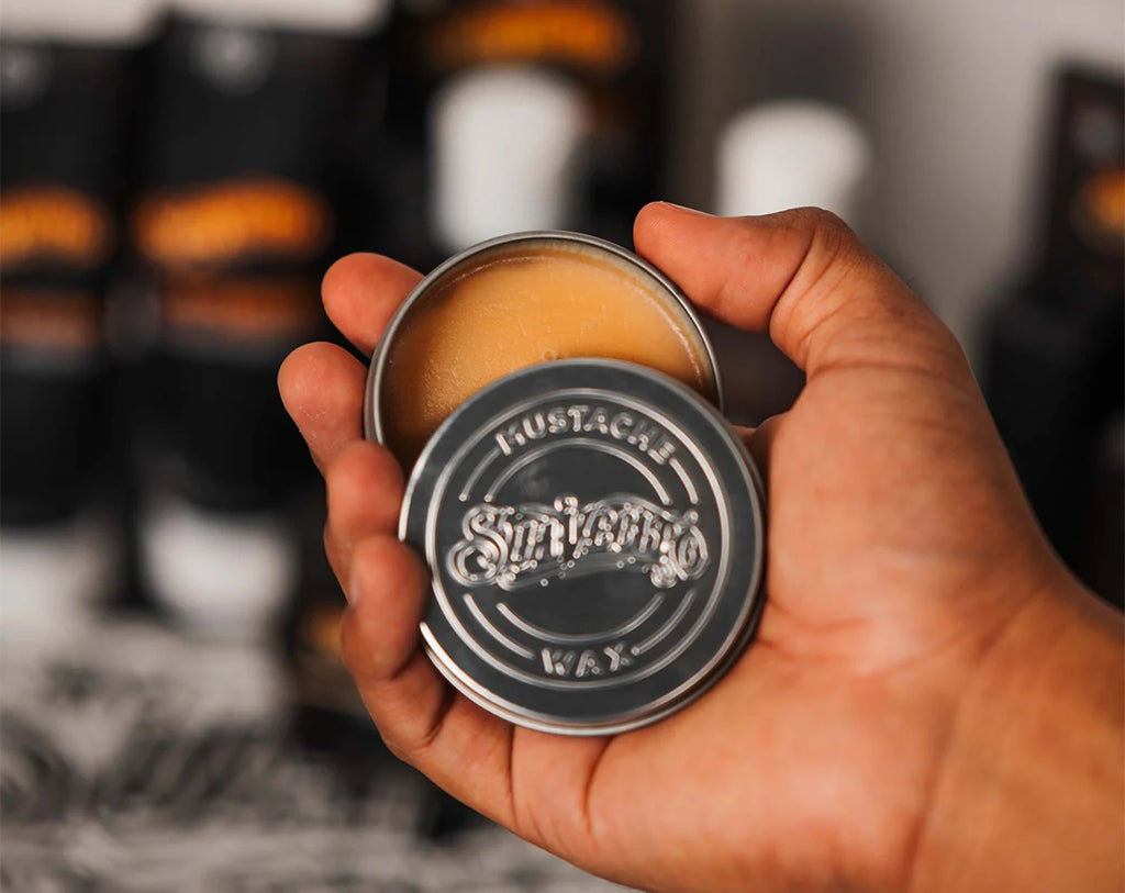 Model holding the open can of Mustache Wax Whiskey Bar