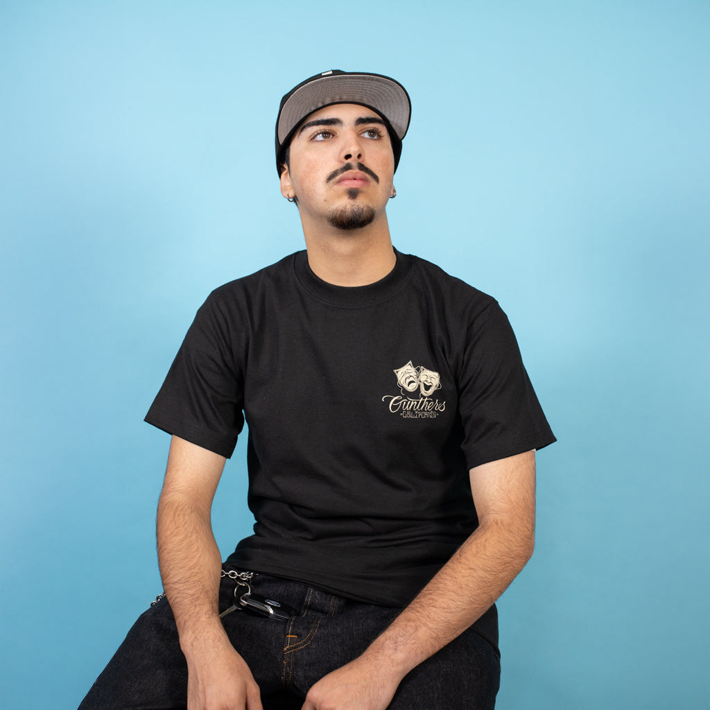 Man wearing a black t-shirt with a logo on a blue background