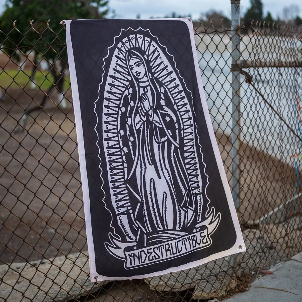 Poster of a religious figure with 'Indestructible' text against a chain-link fence.