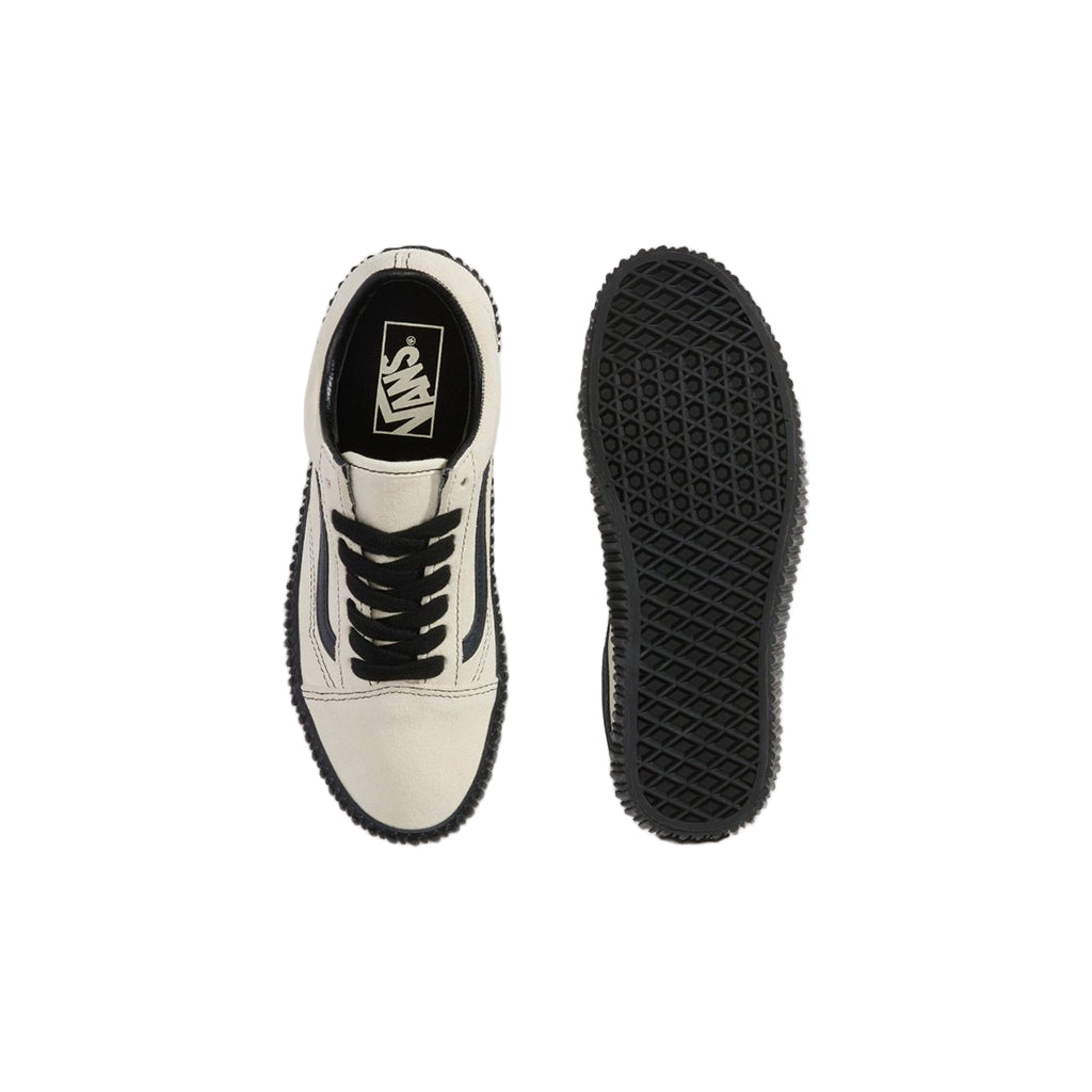 White sneaker with black sole on a light gray background
