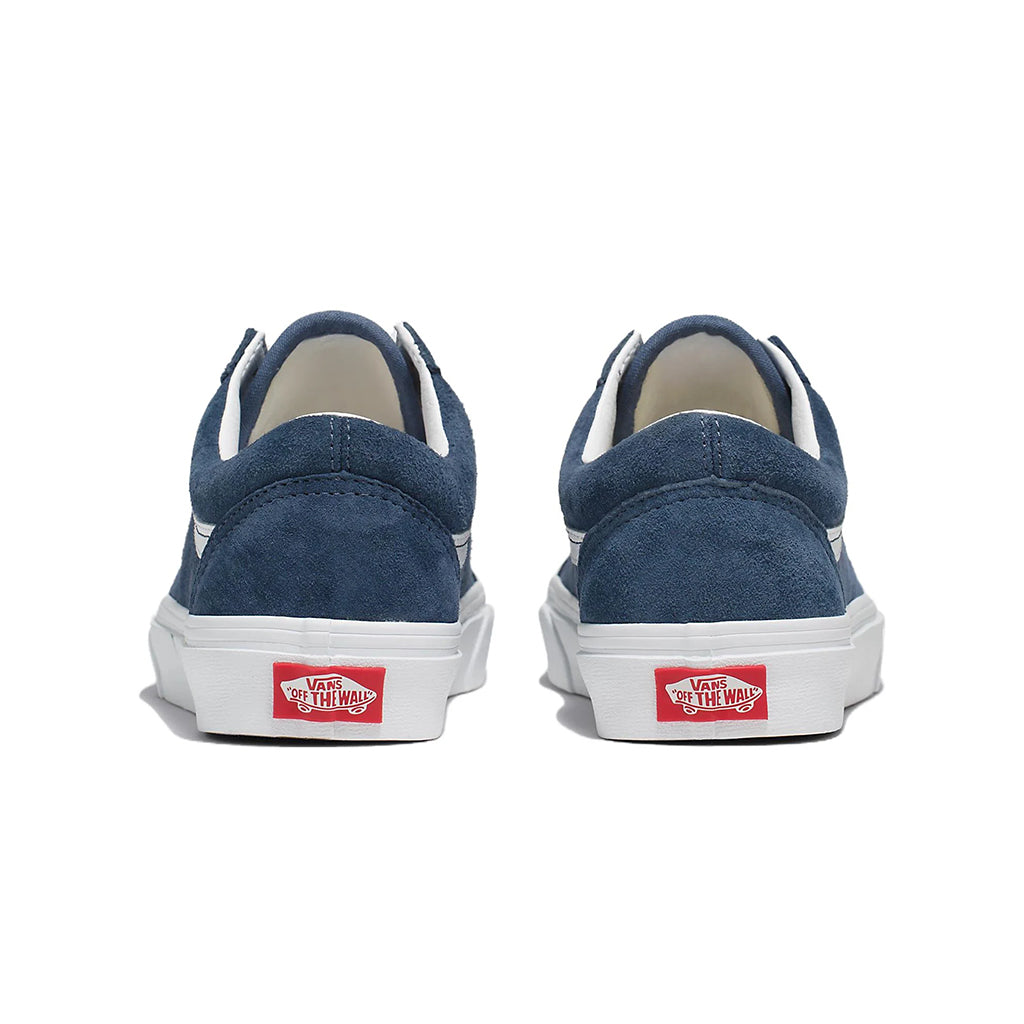 Blue sneakers with white soles and red Vans logo on a white background