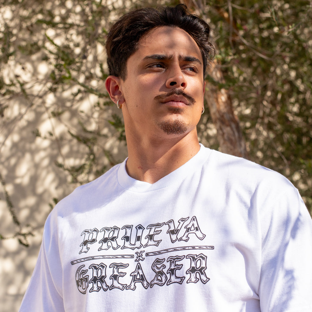 Man wearing a white t-shirt with text outdoors