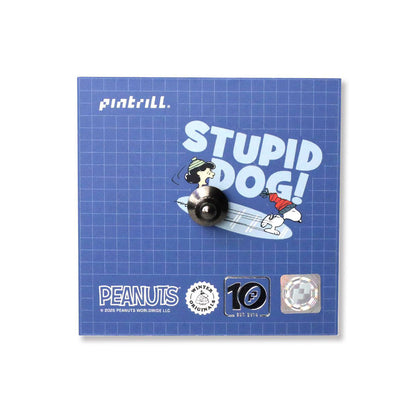Pin with cartoon character and 'STUPID DOG!' text on a blue grid background, featuring Peanuts branding.