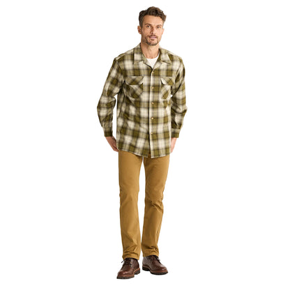 Man wearing a plaid shirt and brown pants on a white background