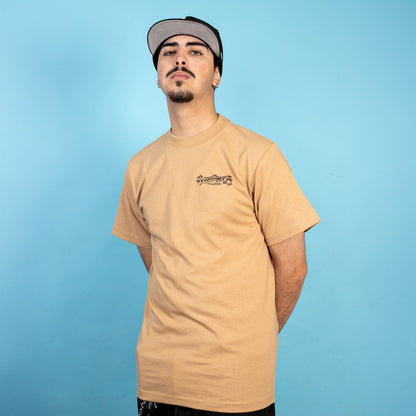 Man wearing a beige t-shirt with a logo on a blue background