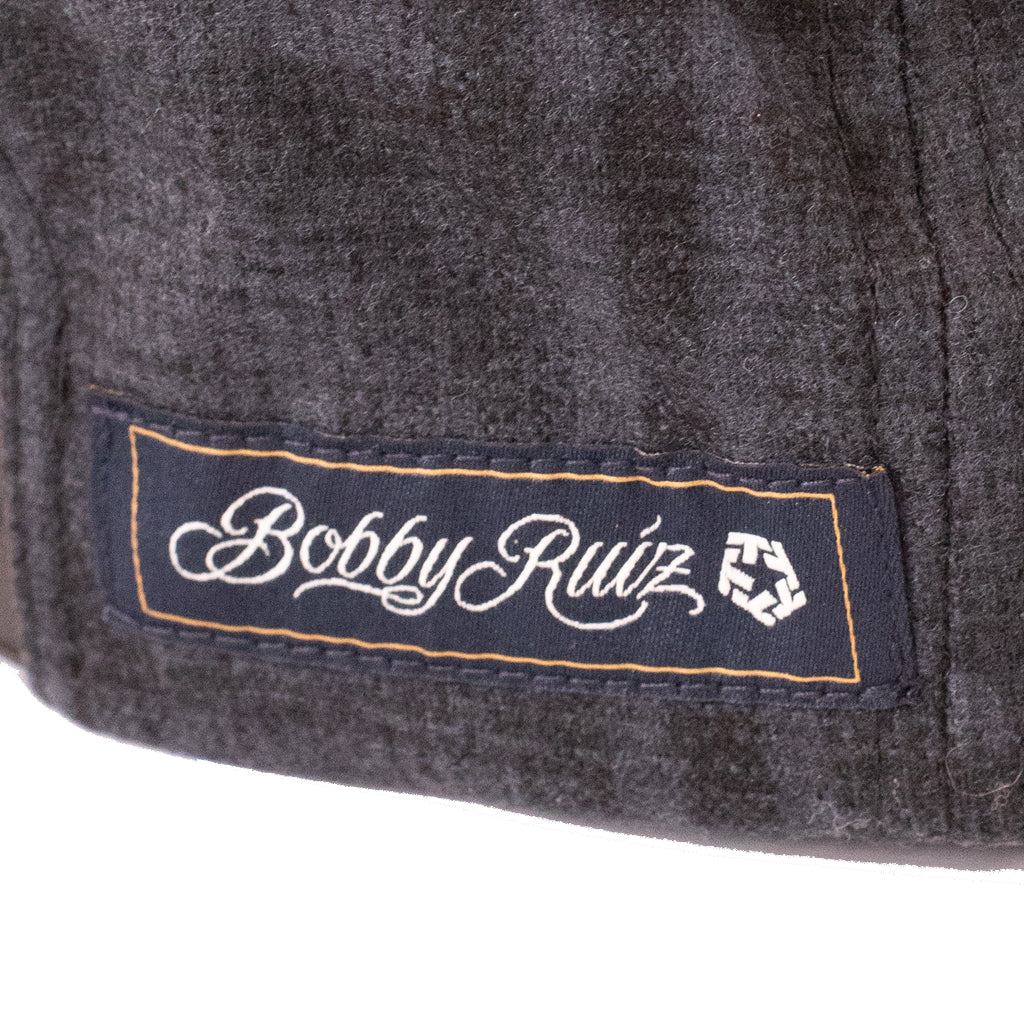 Close-up of a 'Bobby Ruiz' label on a textured surface