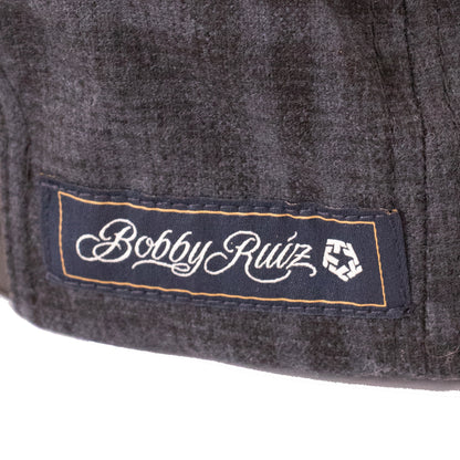 Close-up of a 'Bobby Ruiz' label on a textured surface