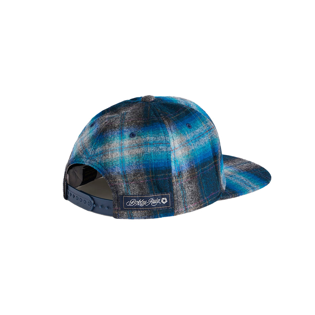 Blue plaid cap with a brand logo on a white background