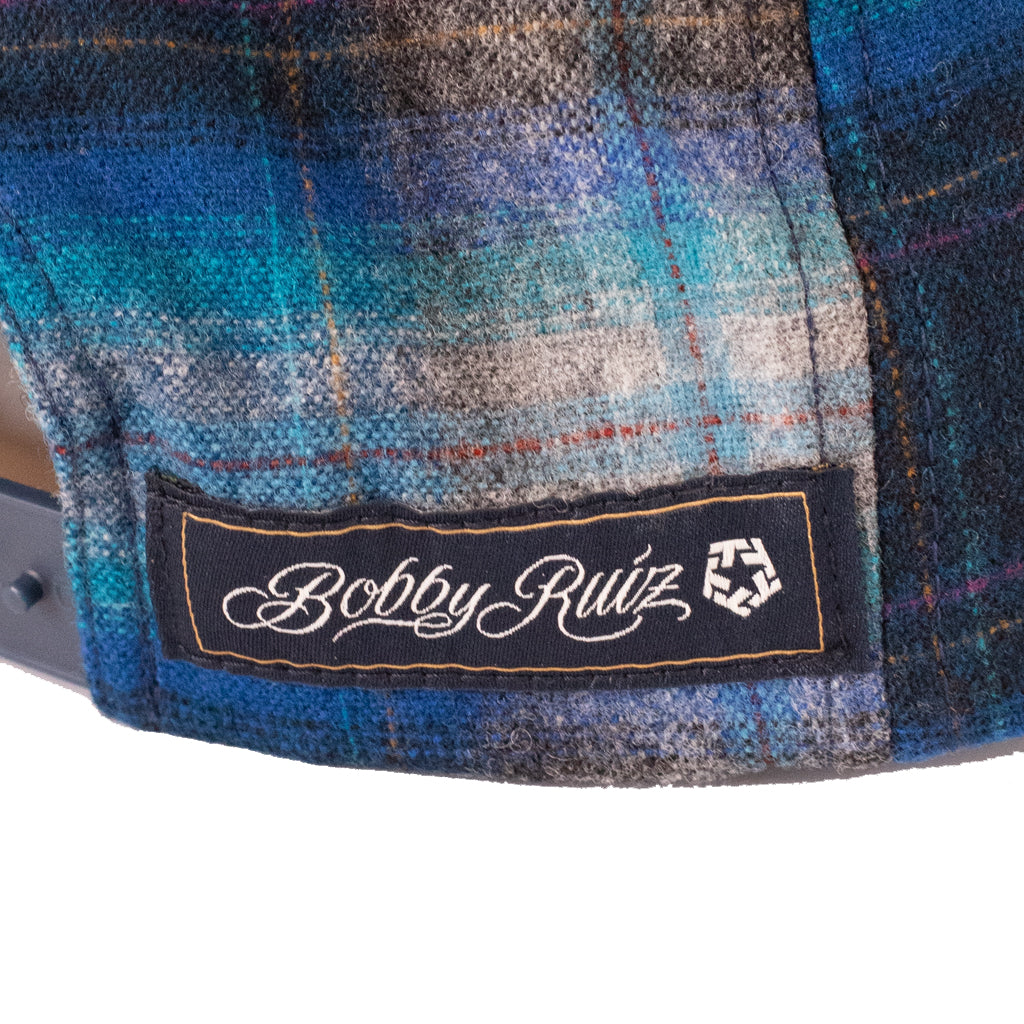Close-up of a blue plaid fabric with a 'Bobby Ruiz' label.