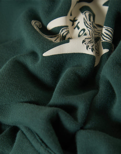 Close-up of a green garment with a white and black logo.