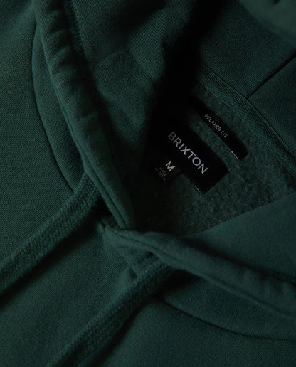 Close-up of a dark green hoodie with a Brixton label.