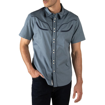 Man wearing a blue short-sleeve shirt with button details on a white background