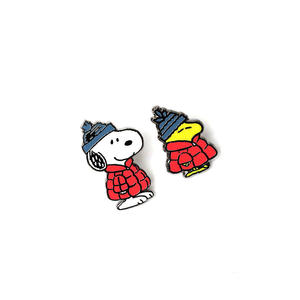 Snoopy and Woodstock wearing winter hats and scarves on a white background