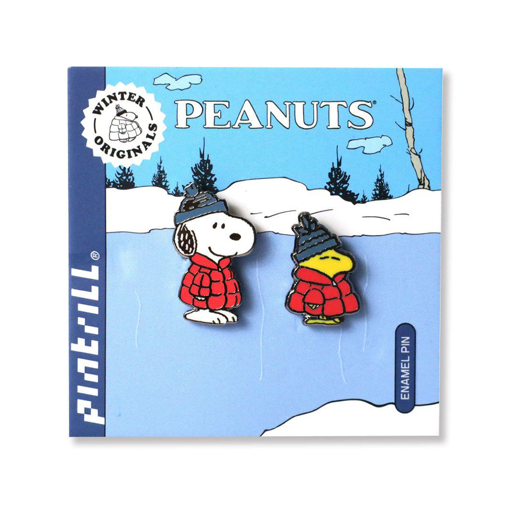 Snoopy and Woodstock enamel pins on a blue card with winter scene