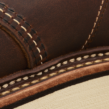 Close-up of brown leather bot with white stitching 
