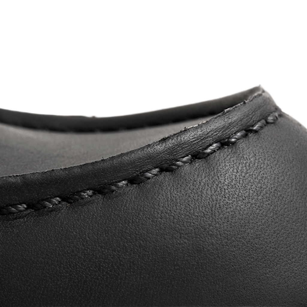 Close-up of black leather product with visible stitching on a white background