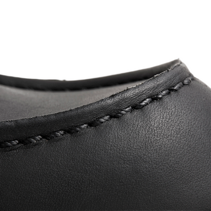 Close-up of black leather product with visible stitching on a white background