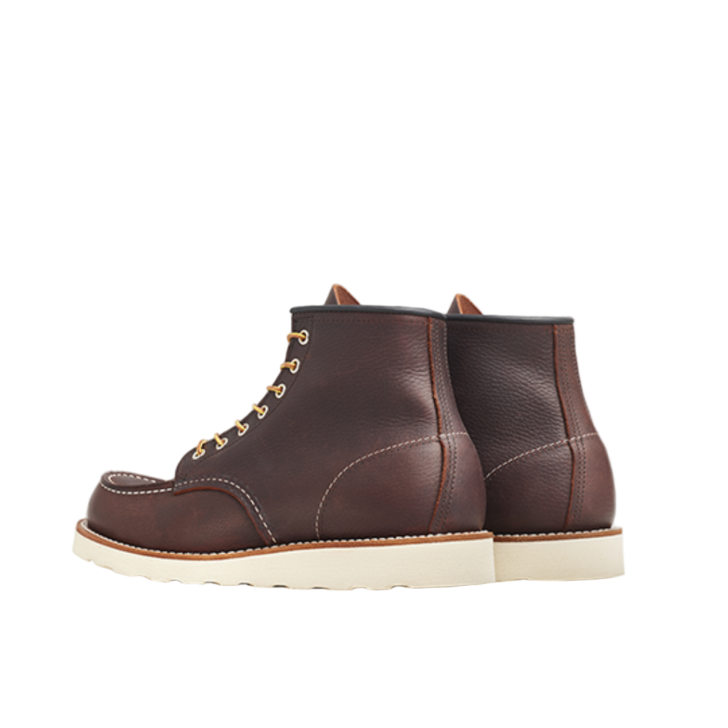 Pair of brown leather boots with white soles on a white background