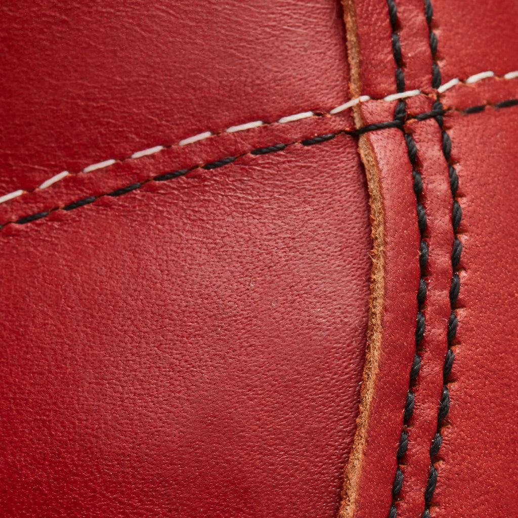 Close-up of red leather with black and white stitching