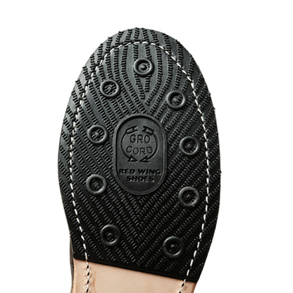 Close-up of a black shoe sole with 'Red Wing Shoes' branding on a white background