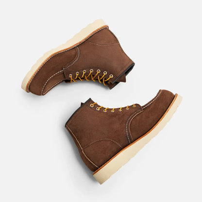Pair of brown suede boots with beige soles on a white background