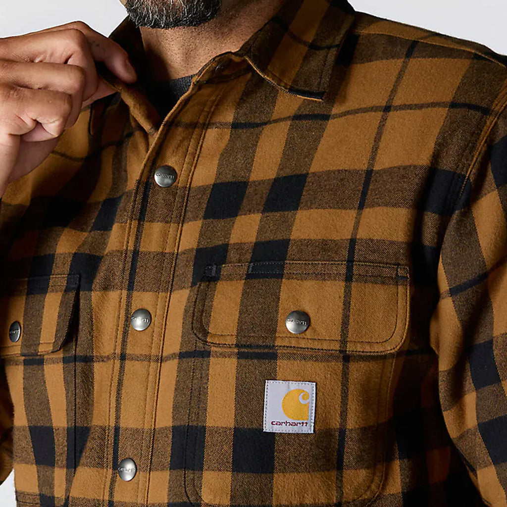 Brown and black plaid shirt with visible Carhartt logo on a white background