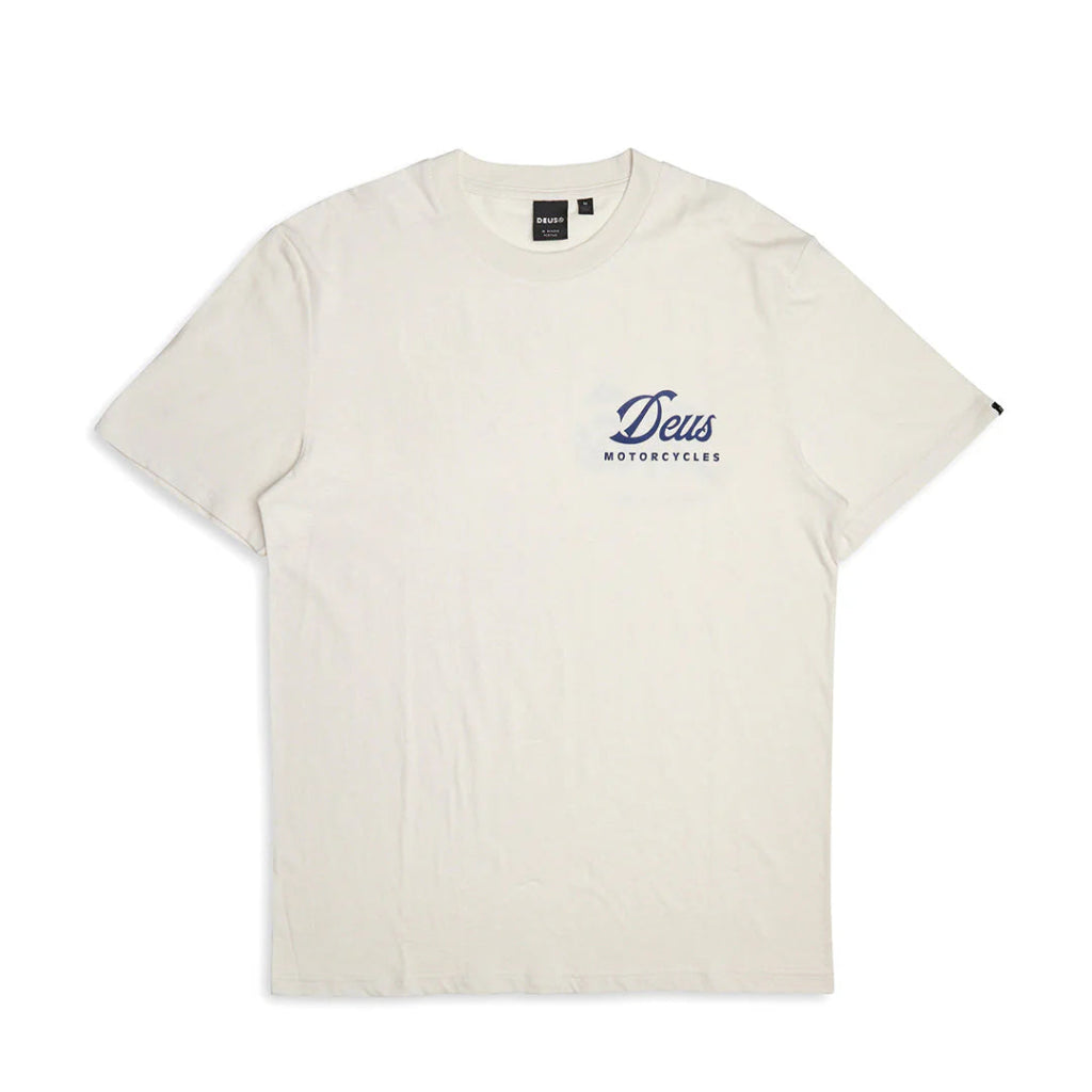 An off-white crewneck t-shirt with a small navy blue 'Deus Motorcycles' logo printed on the left chest, displayed flat against a white background.