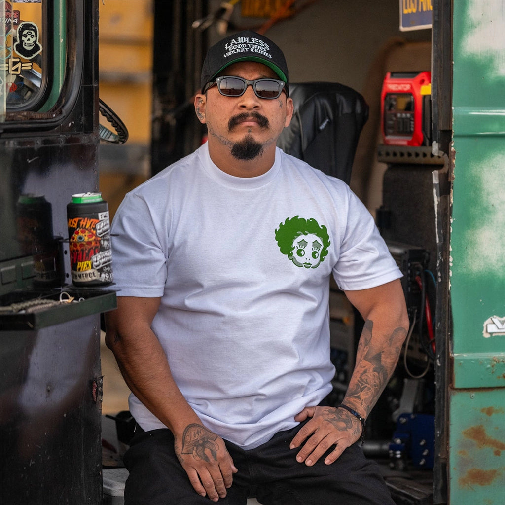Man wearing a white t-shirt with a green logo in a workshop setting