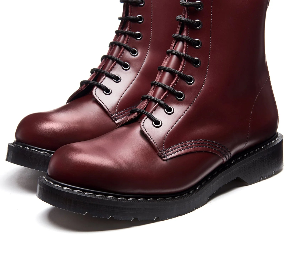 Pair of maroon boots with black laces on a white background