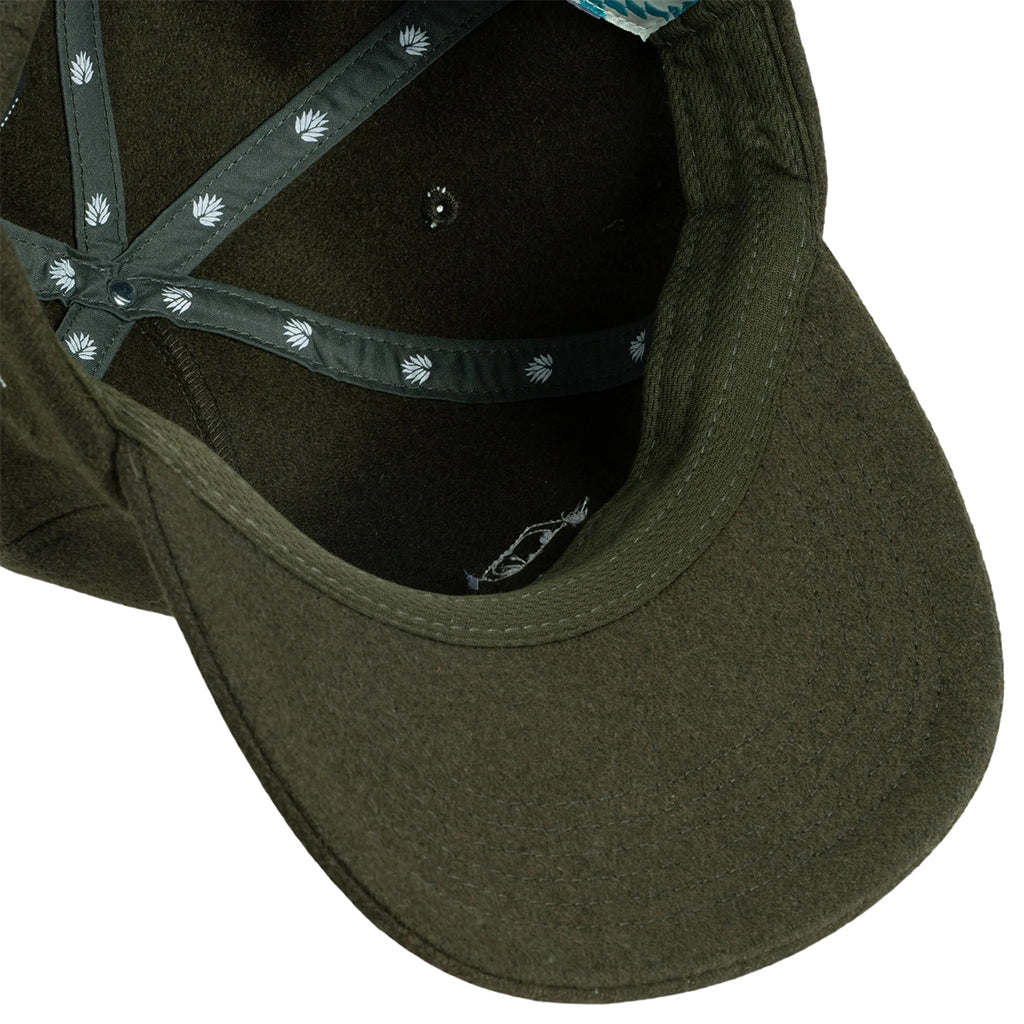 Close-up of a green cap with a patterned band on a white background