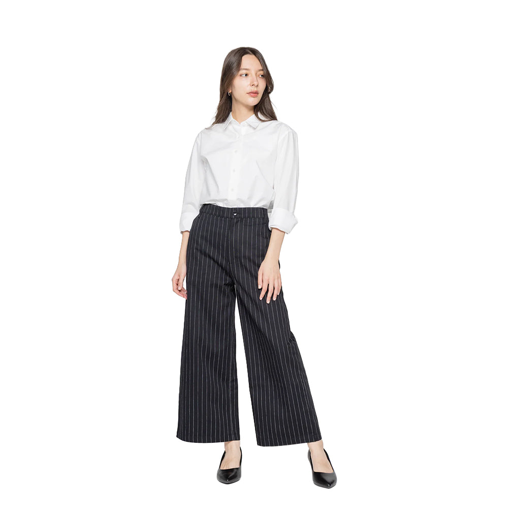 Woman wearing a white shirt and black pinstripe pants on a white background