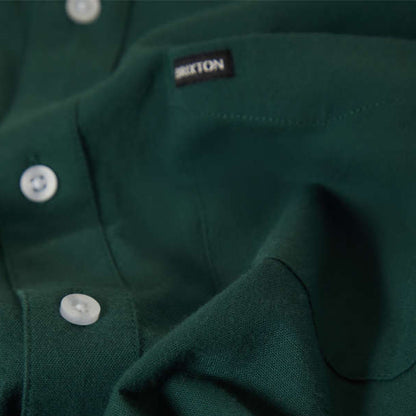 Close-up of a green shirt with Brixton logo on chest pocket