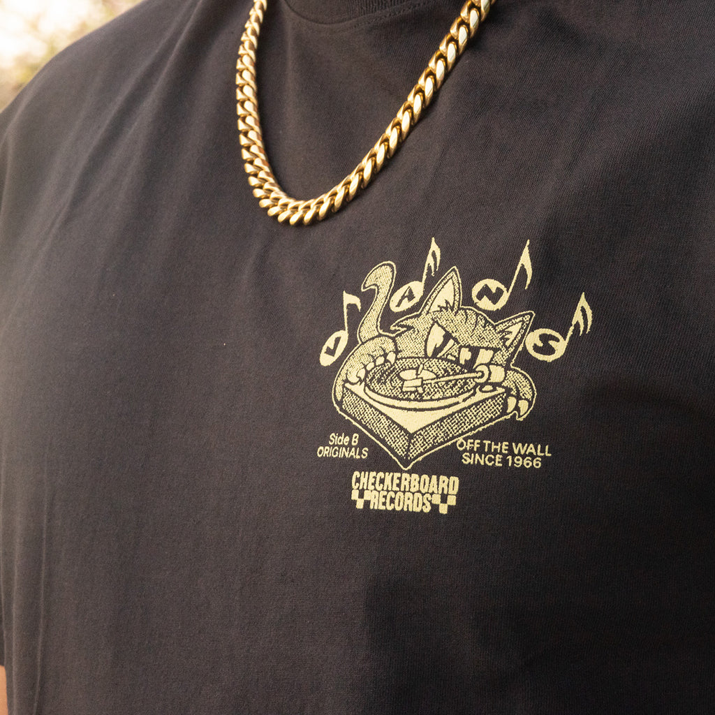 Black t-shirt with a gold graphic design and text, worn by a person.