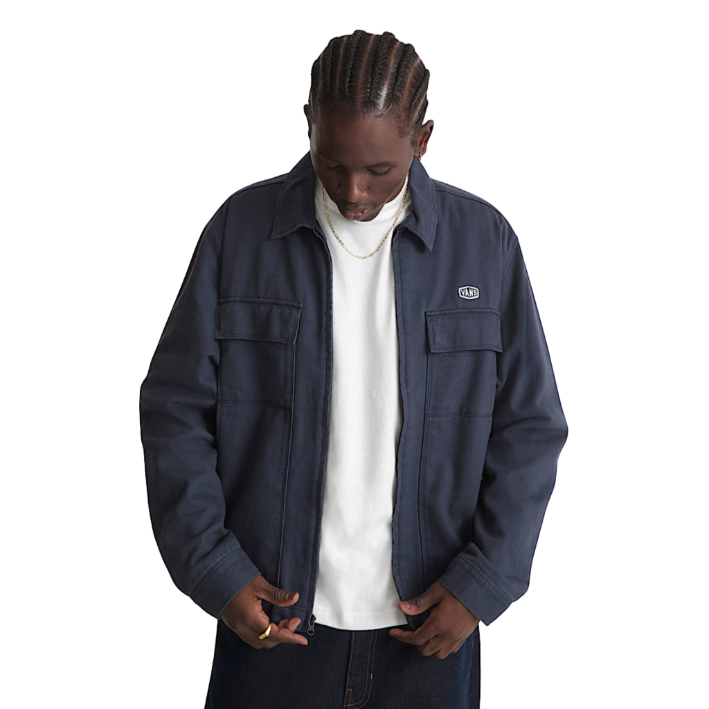 Person wearing a navy blue jacket over a white shirt on a plain white background