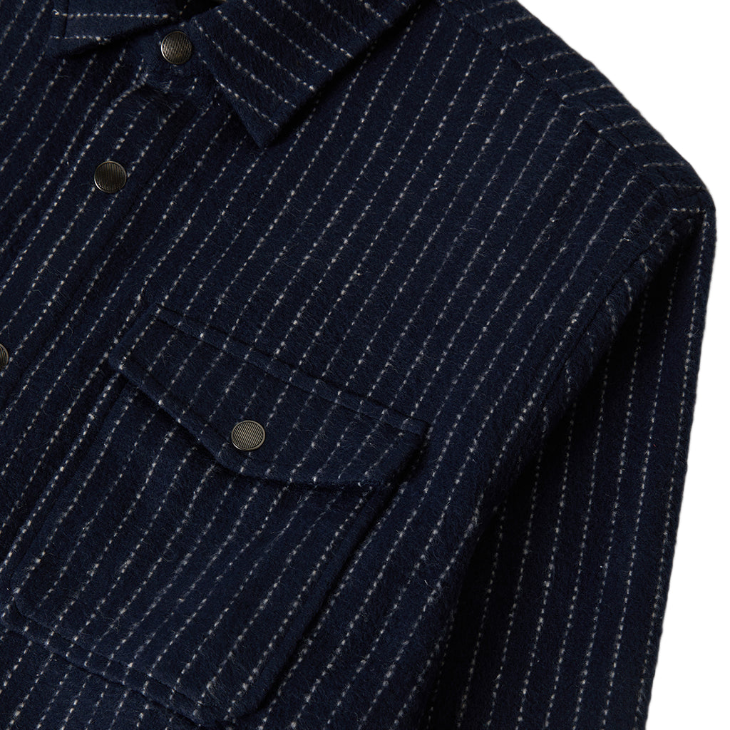 Close-up of a navy pinstripe shirt with button details on a white background