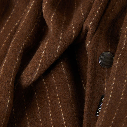 Close-up of a brown textured fabric with a button and visible brand name.