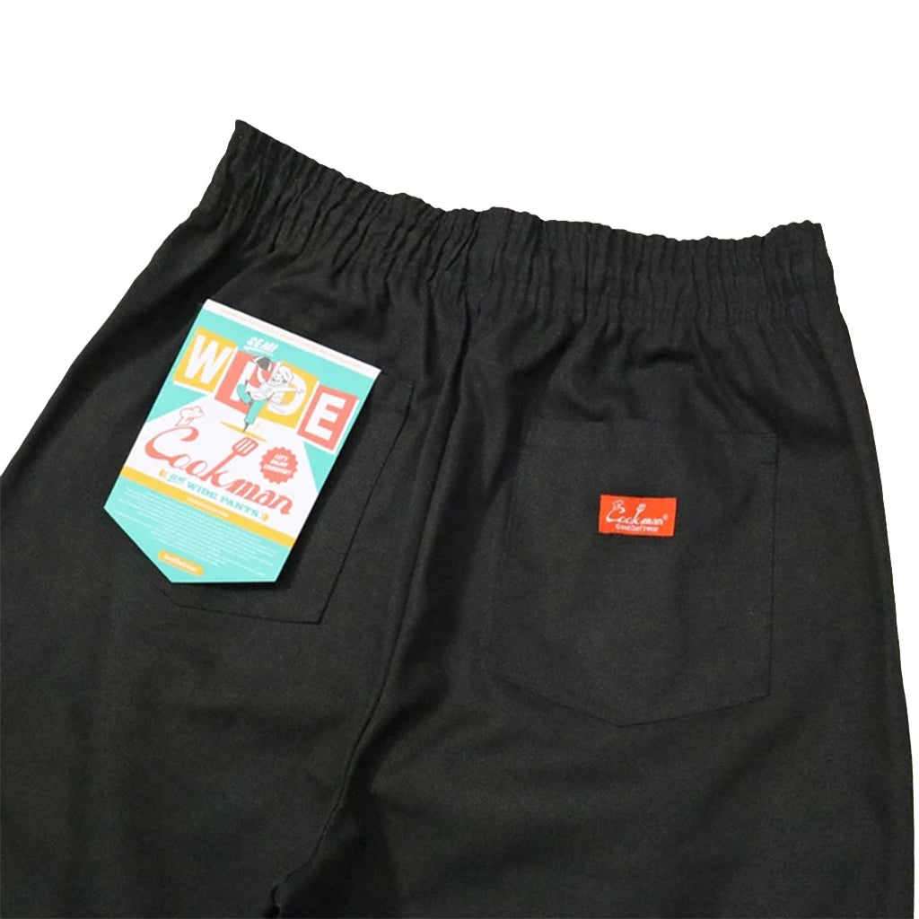 Black pants with a brand label on a white background