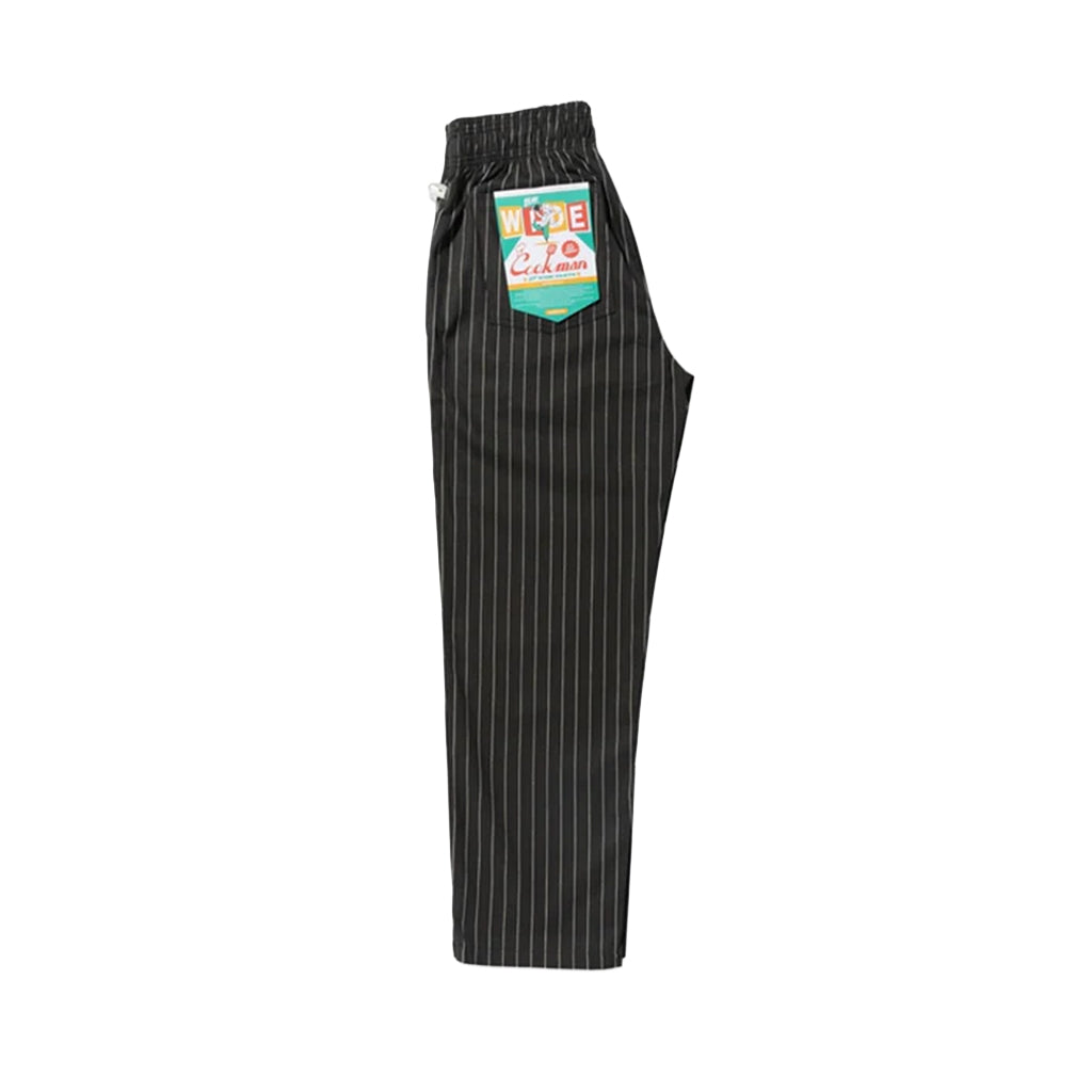 Black pinstripe pants with a brand label on a white background