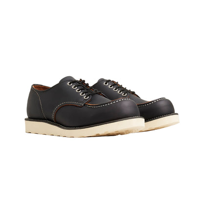 Pair of black leather shoes with white soles on a white background