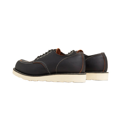Pair of black leather shoes with white soles on a white background
